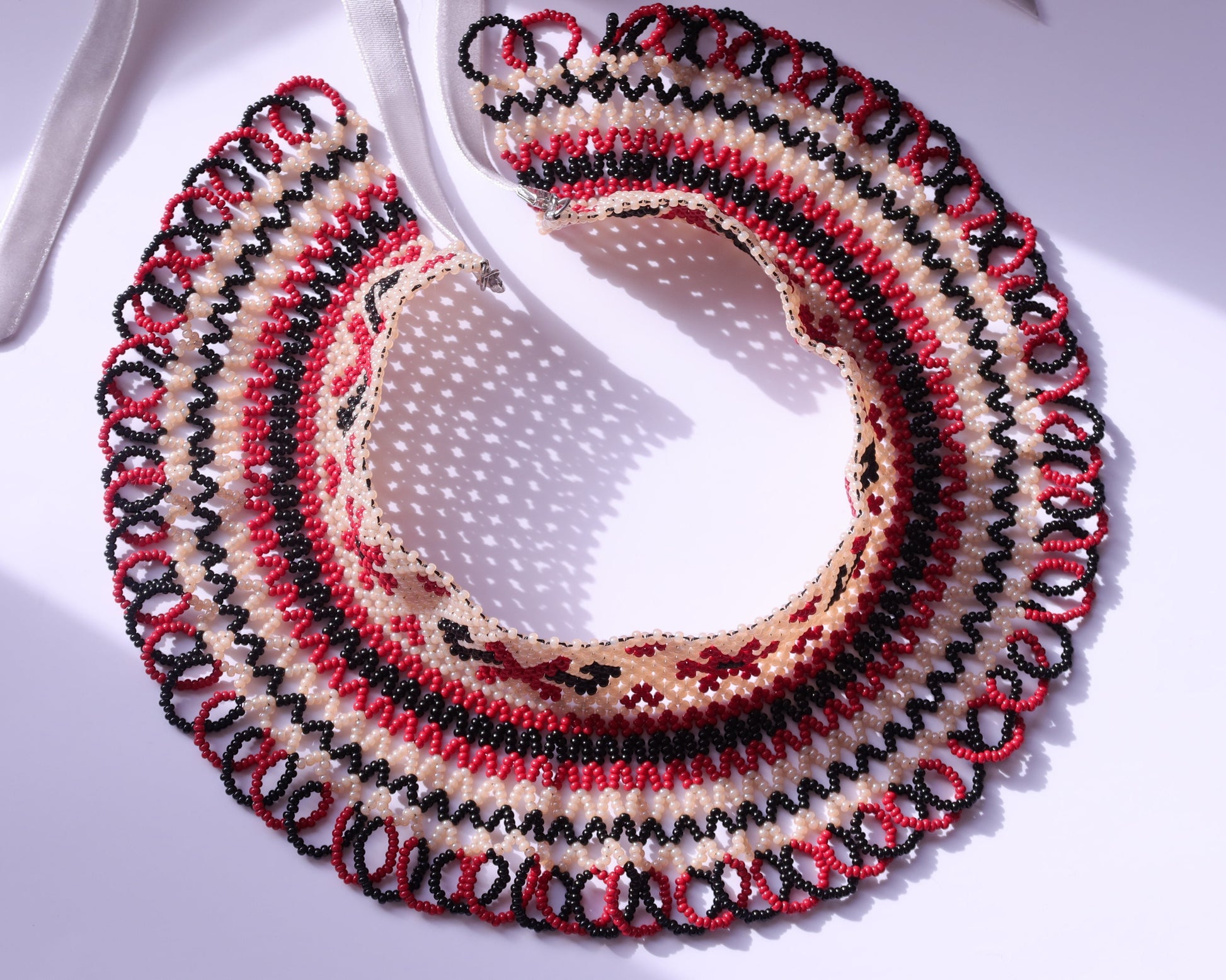 Comely UA Silyanka "Heritage of Pokuttia" beaded necklace in cream, red, and black with traditional diamond and cross motifs.