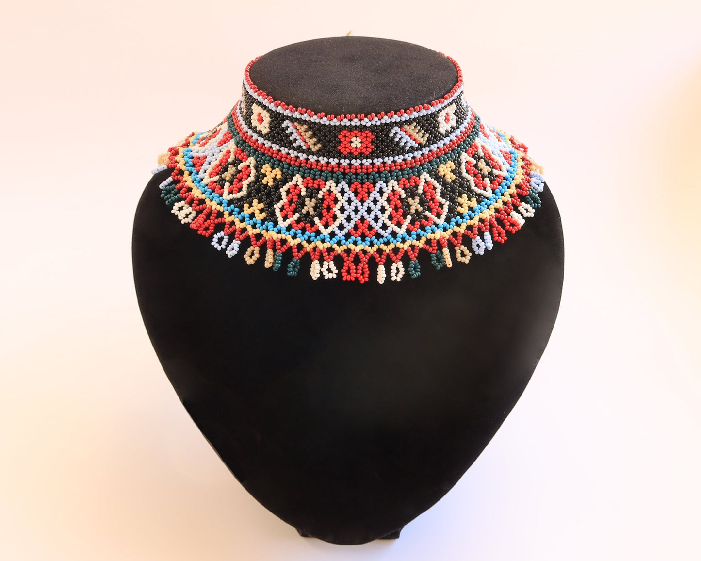 Comely UA two-part Silyanka Ladder beaded necklace with red, black, white, blue, yellow, and green geometric patterns and fringe.