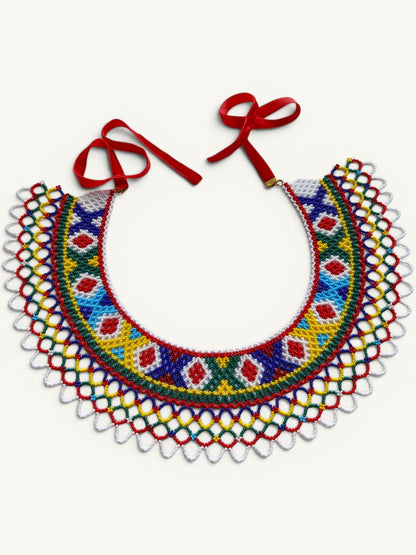 Comely UA Silyanka Lado beaded necklace with diamond and cross motifs in red, blue, yellow, green, and white. Features red velvet ties.