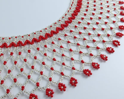 Comely UA Silyanka Solar Crown necklace with red floral bead accents on a silver web pattern.