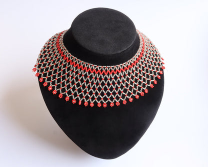 Comely UA Silyanka Solar Crown beaded necklace with red floral accents on a silver web pattern.