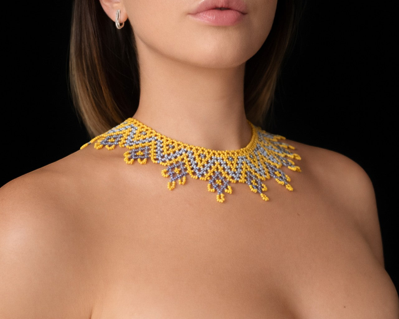 Comely UA Sylianka Zorianytsia beaded necklace in yellow, sky blue, and silver with a jagged wave pattern.