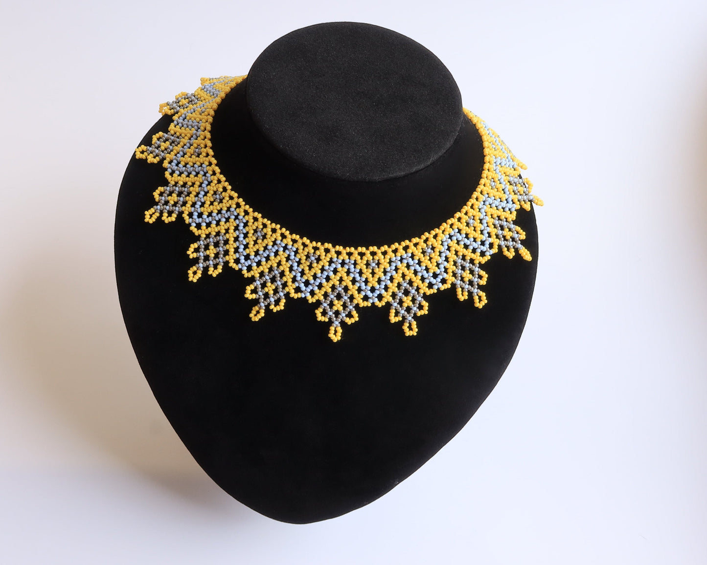 Comely UA Sylianka Zorianytsia beaded necklace in yellow, sky blue, and silver with a jagged wave pattern.