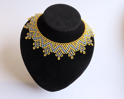 Comely UA Sylianka Zorianytsia beaded necklace in yellow, sky blue, and silver with a jagged wave pattern.