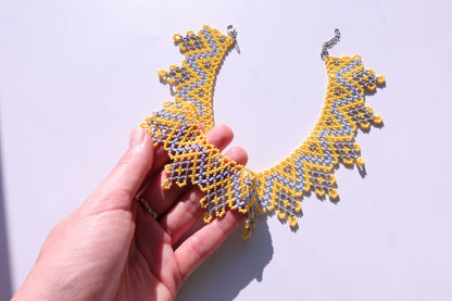 Comely UA Sylianka Zorianytsia beaded necklace in yellow, sky blue, and silver with a jagged wave pattern.