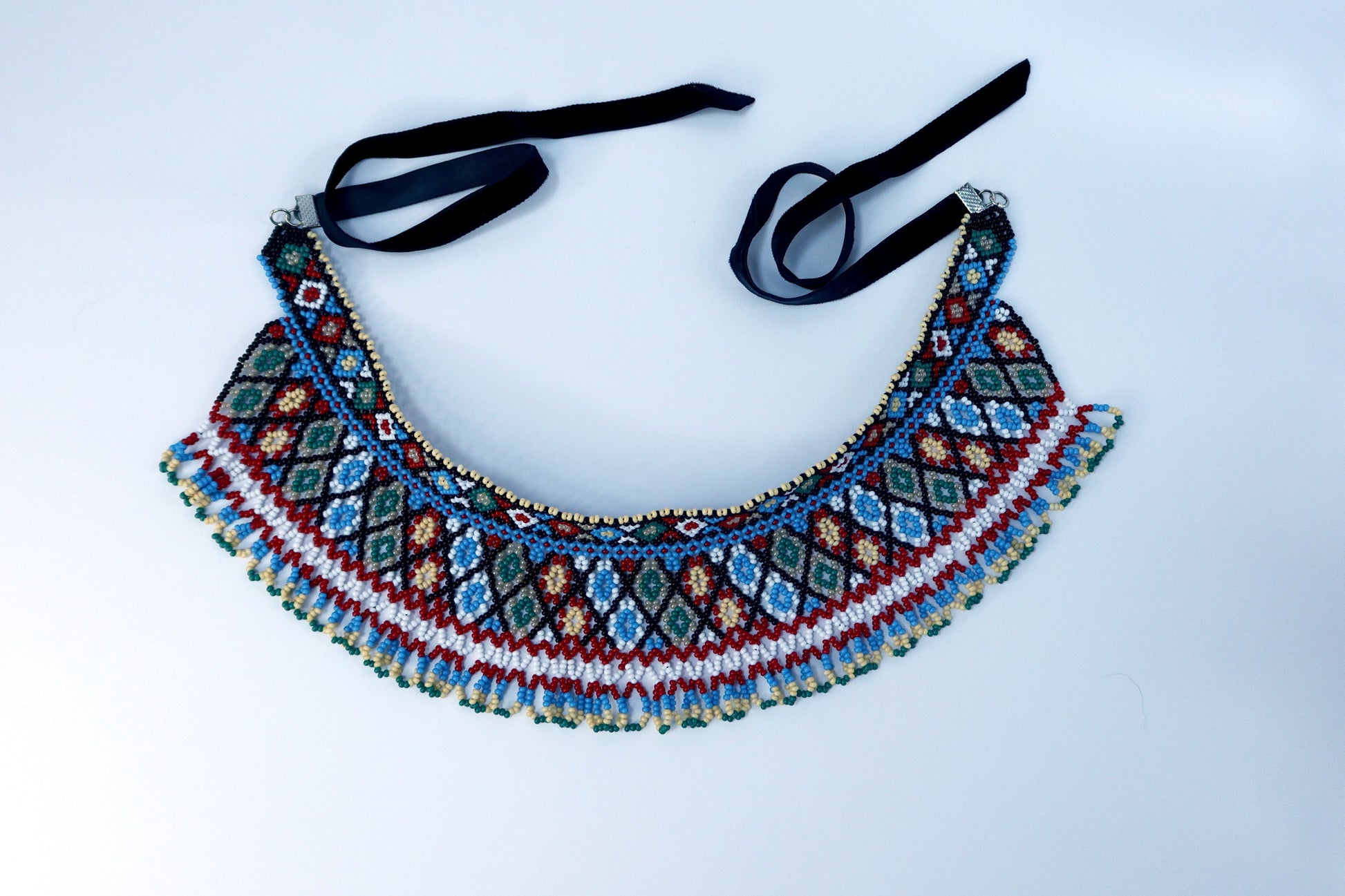 Comely UA two-part beaded necklace with red, blue, green, white, and tan diamond patterns and fringe. Czech seed beads on nylon thread with velvet ribbons.