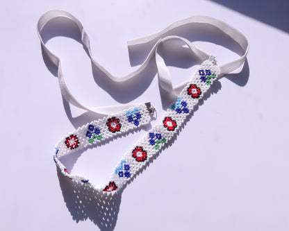 Comely UA white beaded gerdan necklace with red, blue, and green floral motifs and white velvet ribbons.