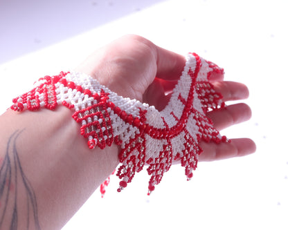 Comely UA "Zakhrava" beaded necklace in red and white Czech seed beads with a jagged sunray design. Adjustable clasp.