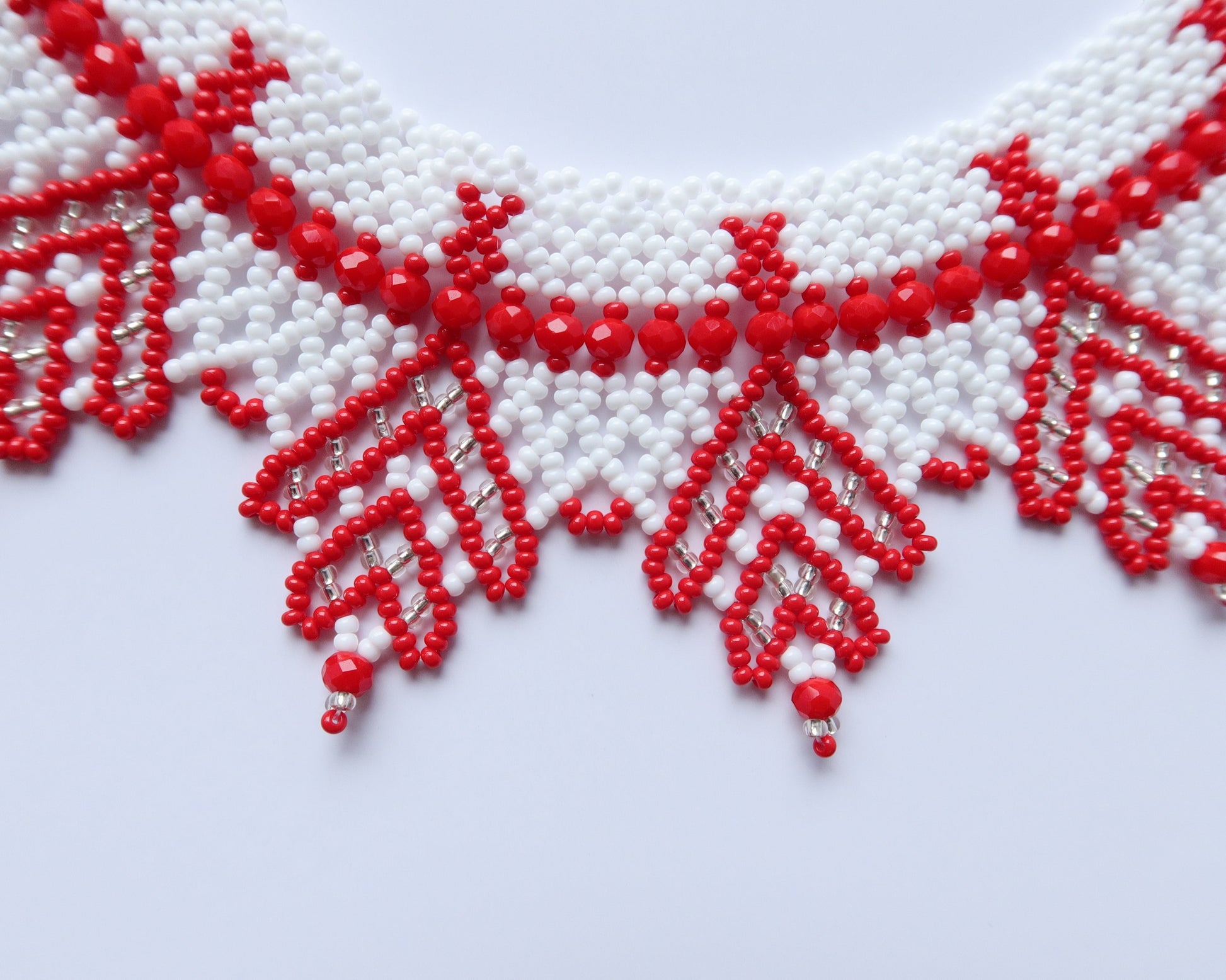 Comely UA "Zakhrava" beaded necklace in red and white Czech seed beads with a jagged edge design.