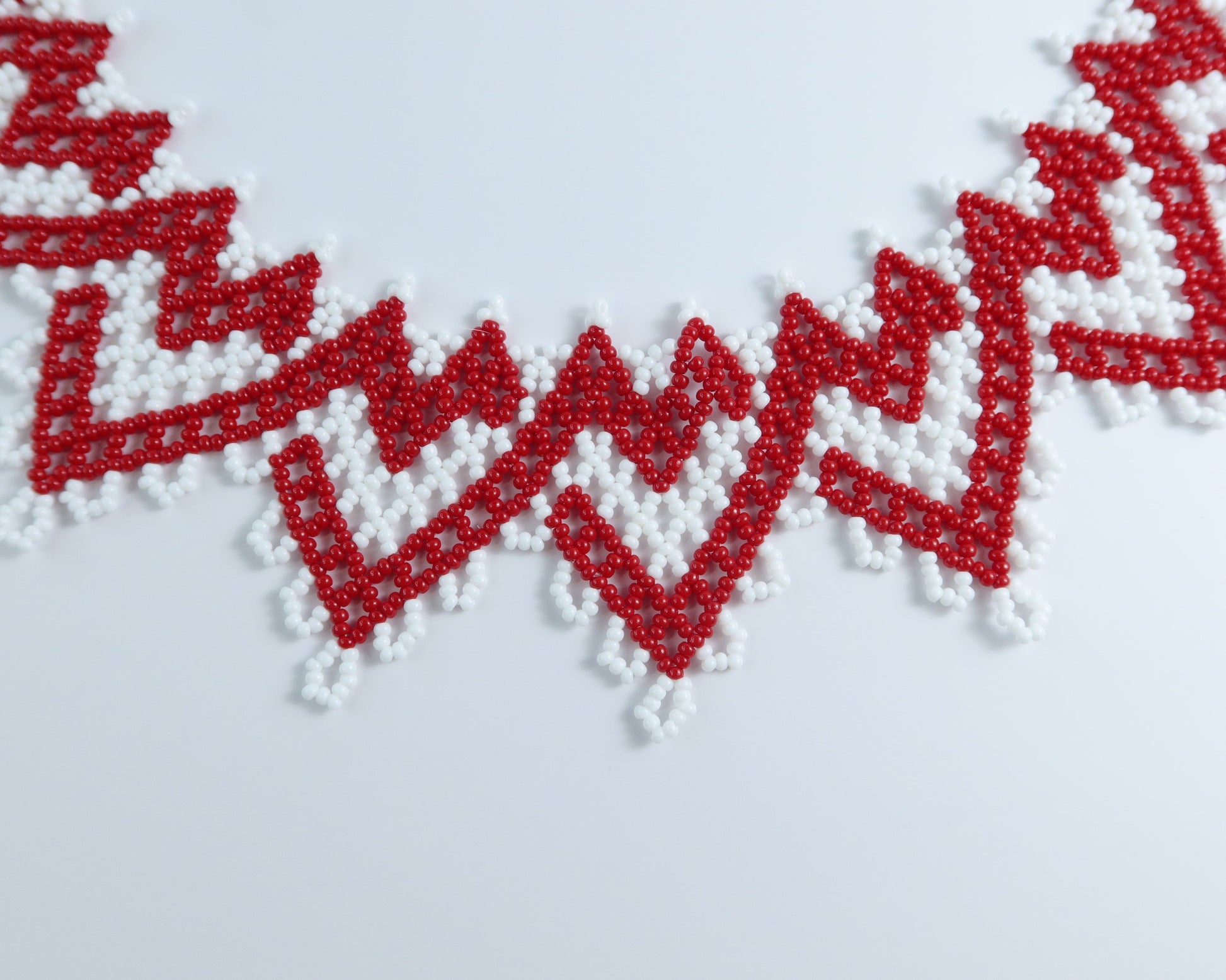 Comely UA red and white zigzag beaded silyanka necklace with velvet ribbon ties. Symbolizes warmth and renewal.