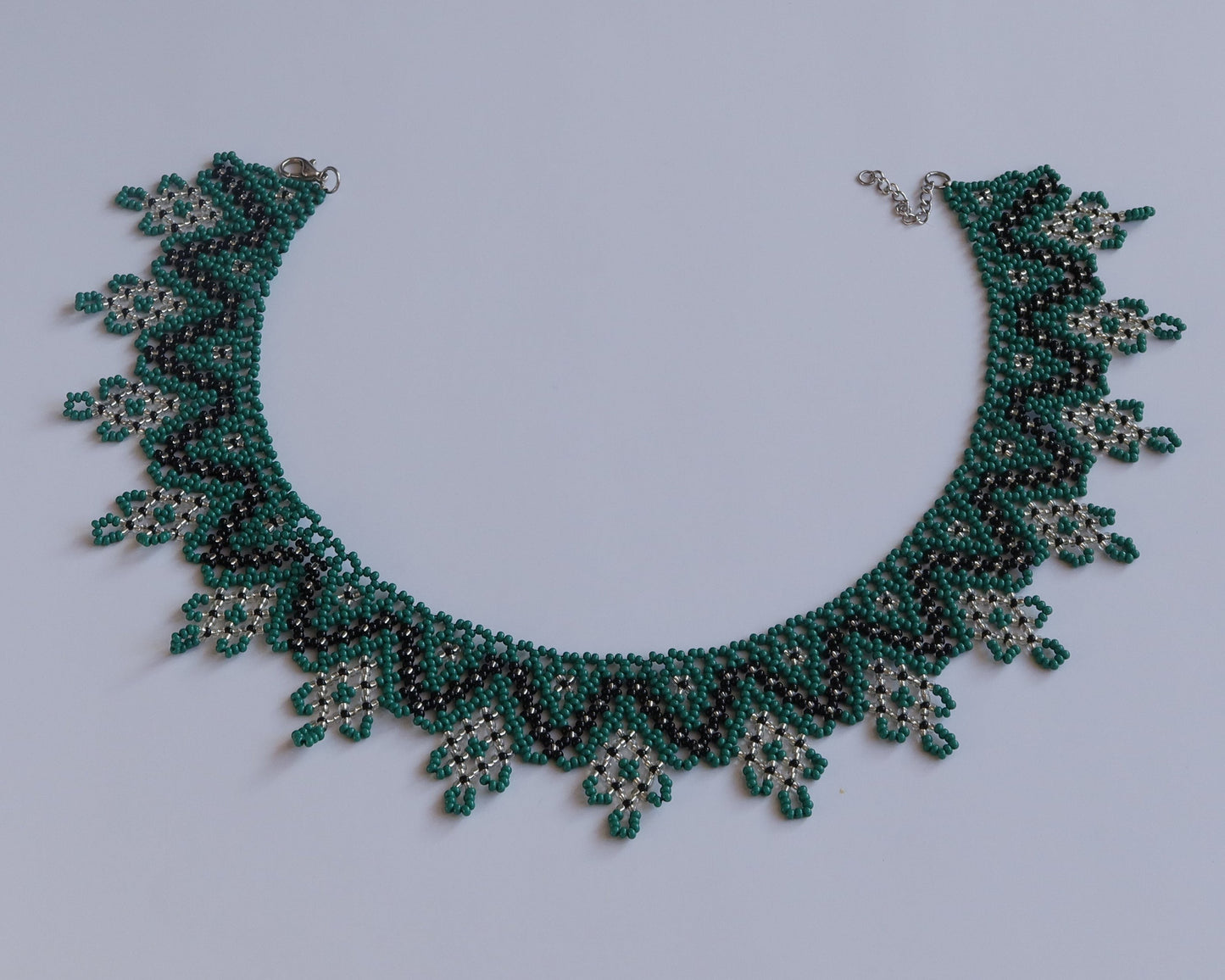 Comely UA Zorianytsia beaded necklace in deep green, black, and yellow. Traditional flat silyanka design with jagged waves.
