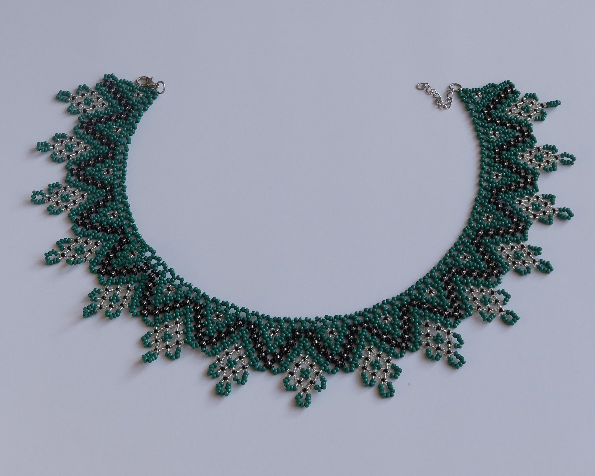 Comely UA Zorianytsia beaded necklace in deep green, black, and yellow. Traditional flat silyanka design with jagged waves.