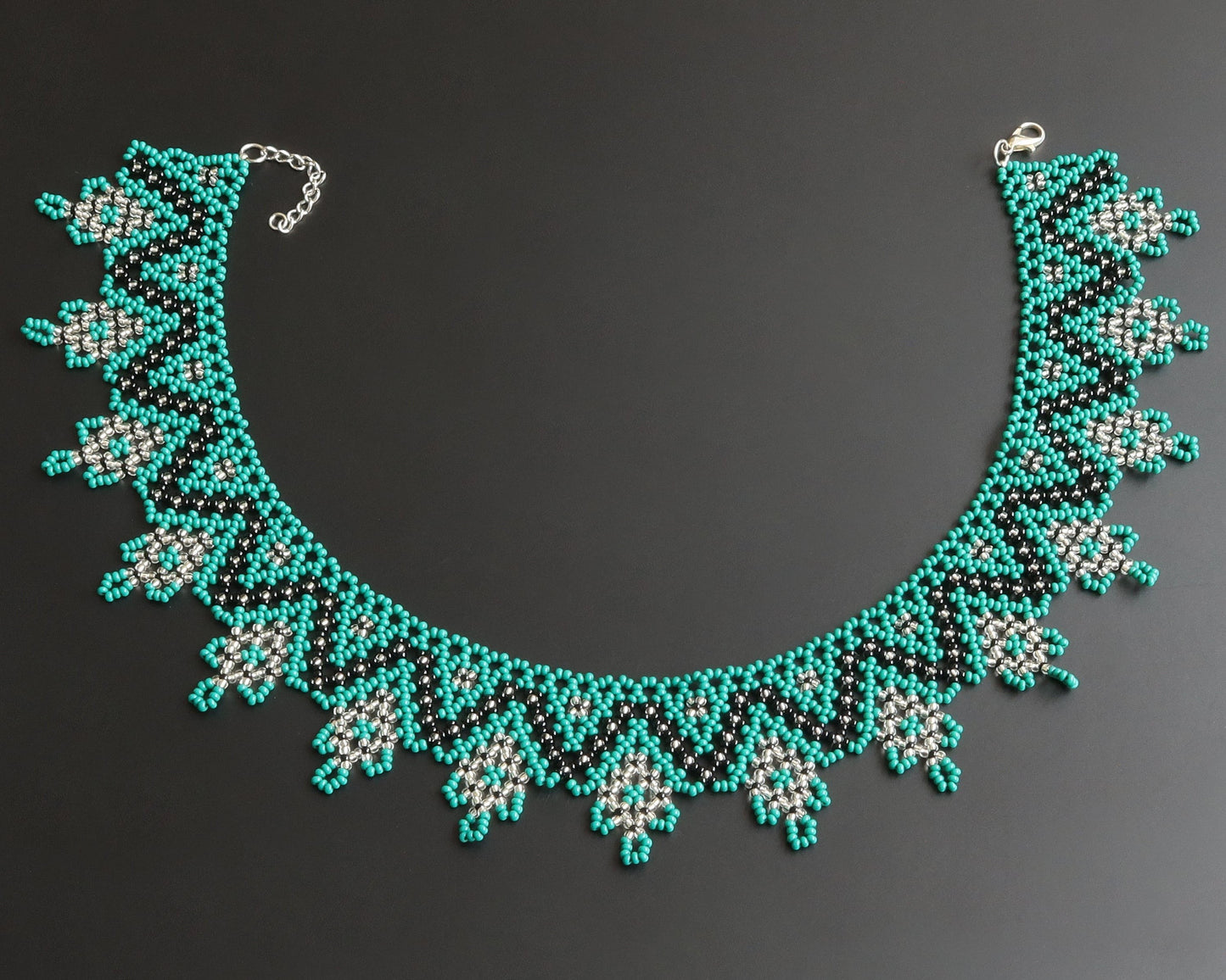 Comely UA Zorianytsia beaded necklace in teal, black, and silver with a jagged pattern. Czech seed beads.