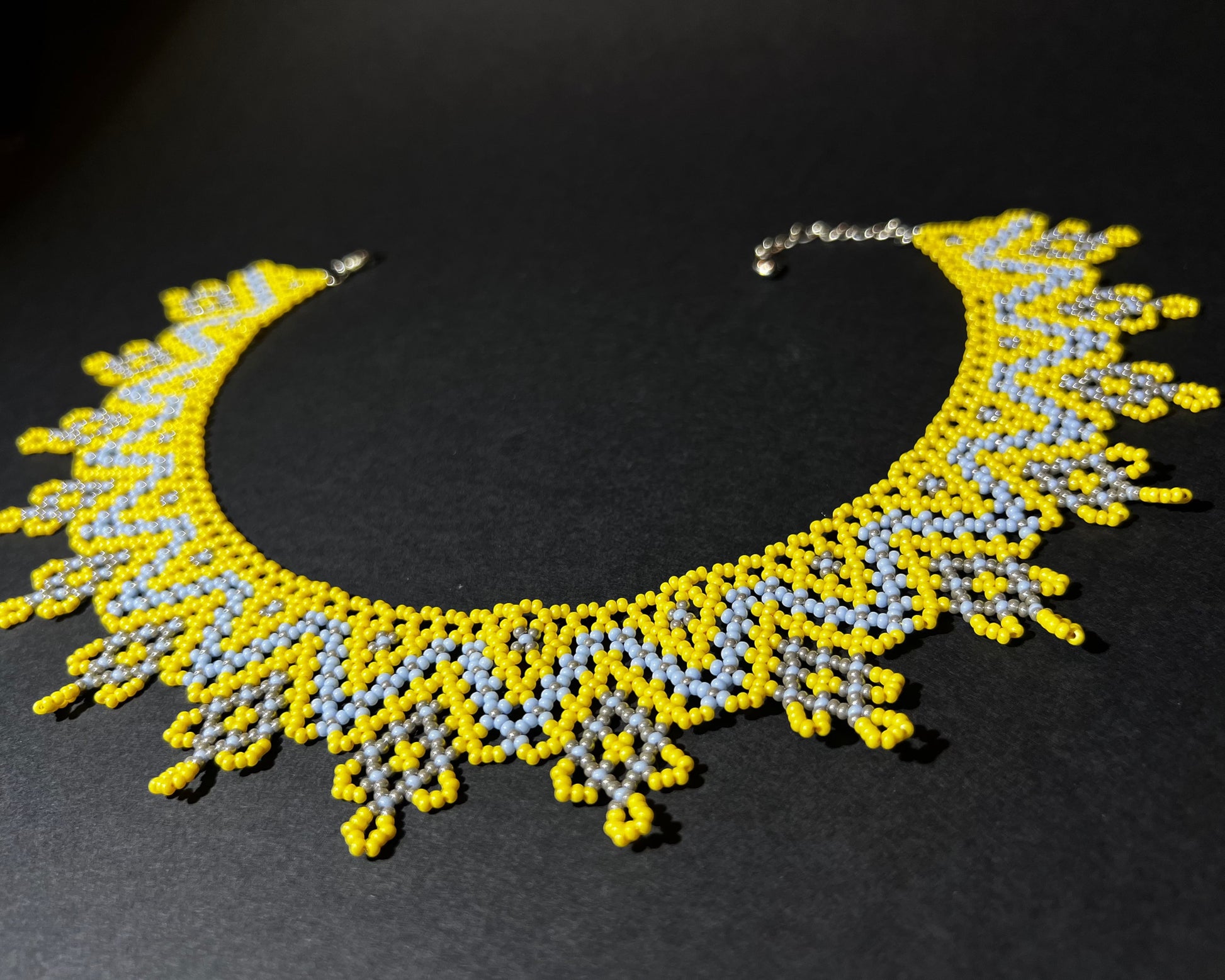 Comely UA "Zorianytsia" beaded necklace in yellow, sky blue, and silver with a jagged wave pattern.