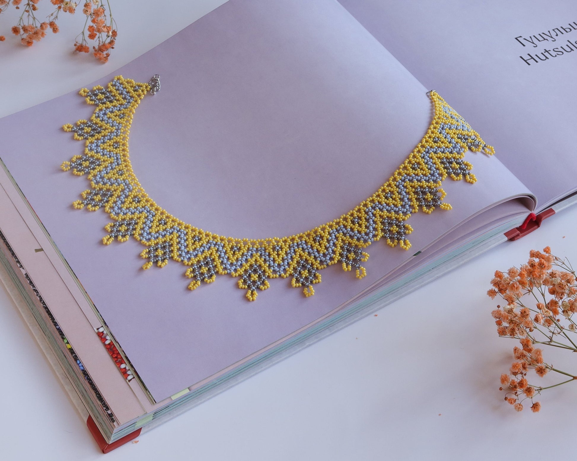 Comely UA "Zorianytsia" beaded necklace in yellow, sky blue, and silver with a jagged wave pattern. Czech seed beads.