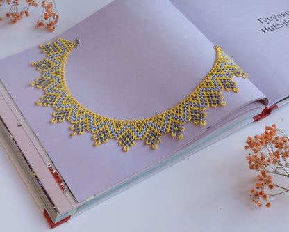 Comely UA "Zorianytsia" beaded necklace in yellow, sky blue, and silver with a jagged wave pattern. Czech seed beads.