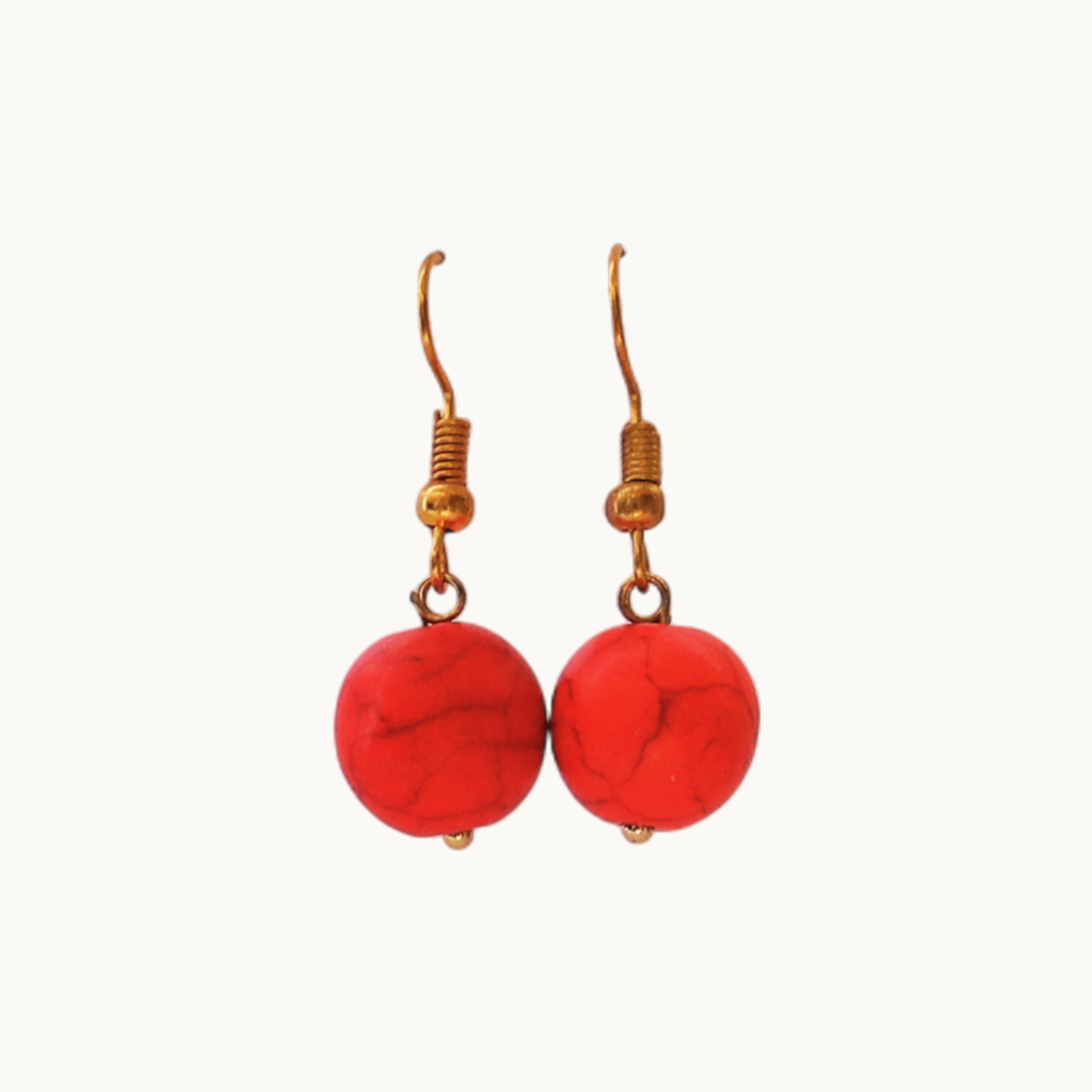 Pair of red earrings with gold hooks on a white background