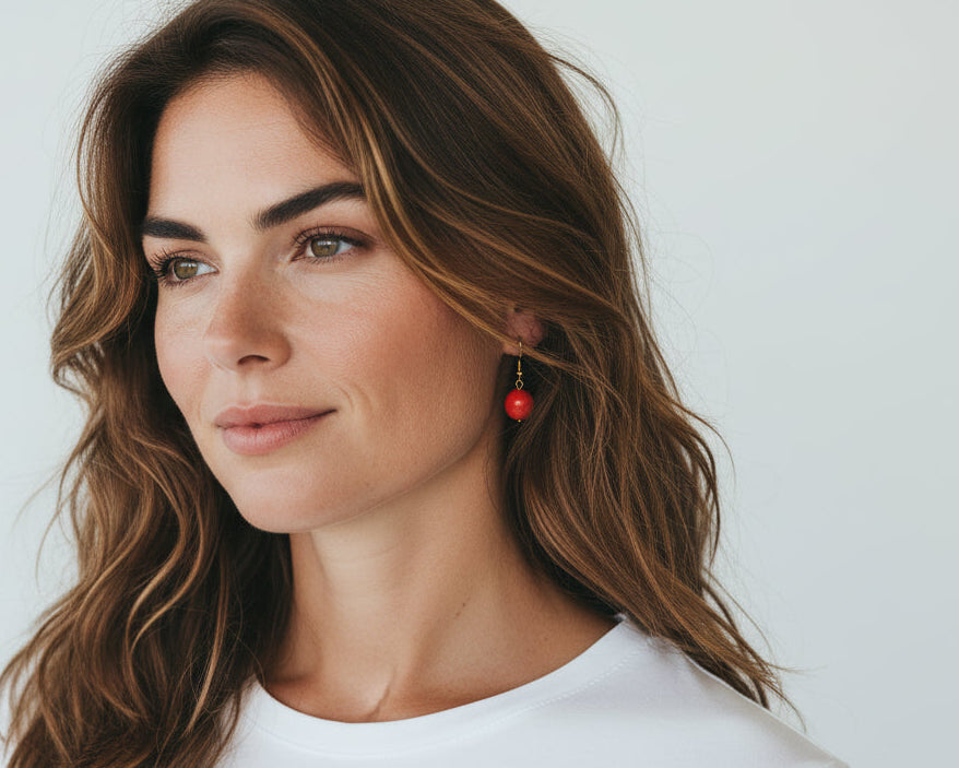 Woman with wavy hair wearing a white shirt against a plain background
